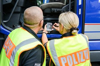 Ein LKW wird von Polizeibeamten kontrolliert.