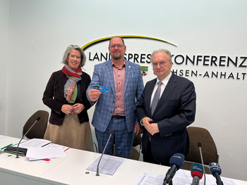 Das Bild zeigt Ministerpräsident Dr. Reiner Haseloff (rechts), Innenministerin Dr. Tamara Zieschang (rechts), Landrat vom Bördekreis, Martin Stichnoth, mit der Bezahlkarte.