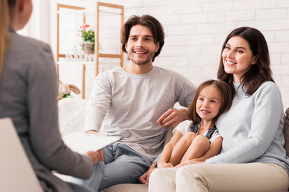 Das Bild zeigt eine Pflegefamilie mit einer Behördenmitarbeiterin.