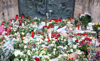 Das Bild zeigt ein Blumenmeer und Kerzen vorm Magdeburger Dom nach dem Attentat auf den Magdeburger Weihnachtsmarkt