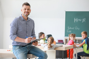 Das Bild zeigt einen Lehrer in der Klasse.